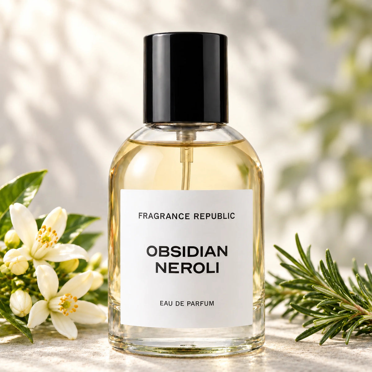 Fragrance Republic Obsidian Neroli eau de parfum bottle beside white flowers and rosemary.