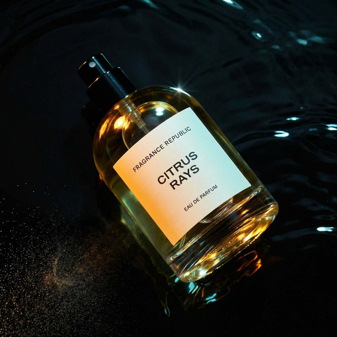 Citrus Rays Eau de Parfum bottle with spray mist on dark reflective water surface