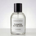 Clear perfume bottle labeled 'Flowers in the Wind' by Fragrance Republic on a white background