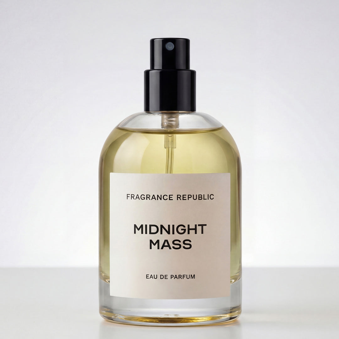 Clear glass perfume bottle labeled 'Midnight Mass Eau de Parfum' with black spray cap