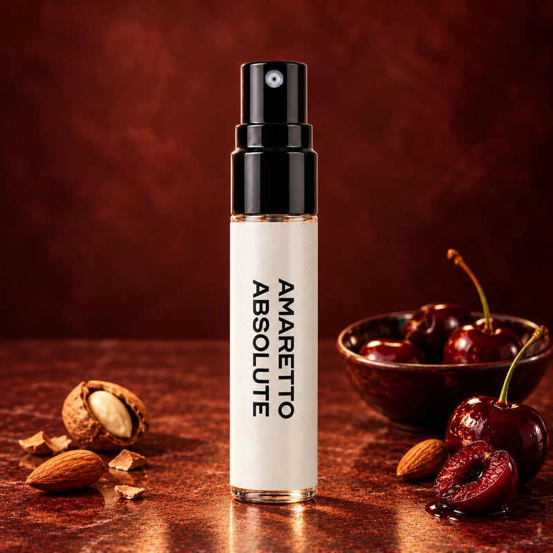 Fragrance Republic Amaretto Absolute 5ml perfume sample spray beside almonds and cherries on a dark red background.