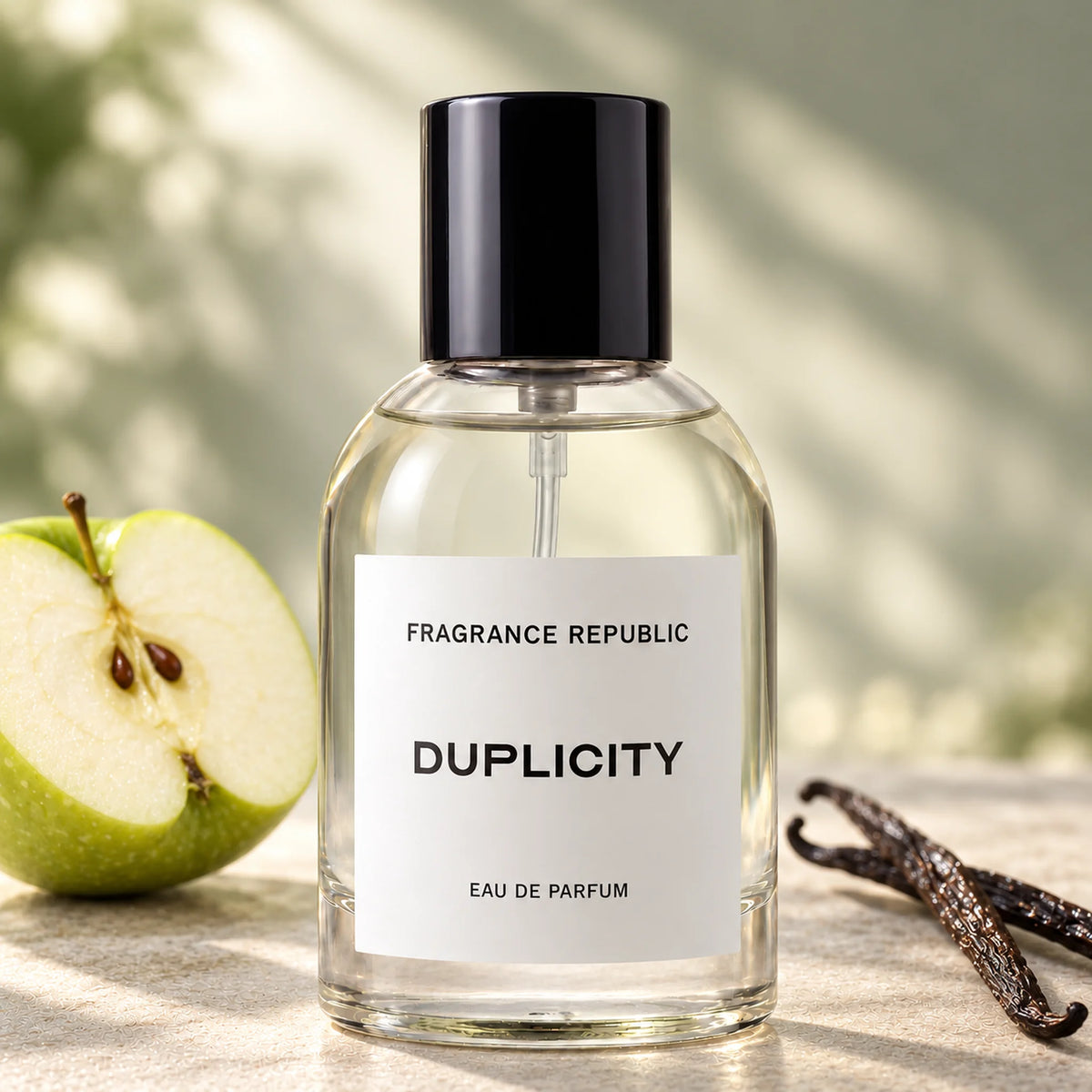 Fragrance Republic Duplicity eau de parfum bottle beside a green apple and vanilla pods.