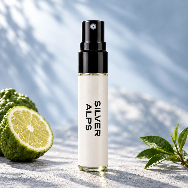 Fragrance Republic Silver Alps 5ml perfume sample spray beside a halved citrus fruit and green tea leaves.